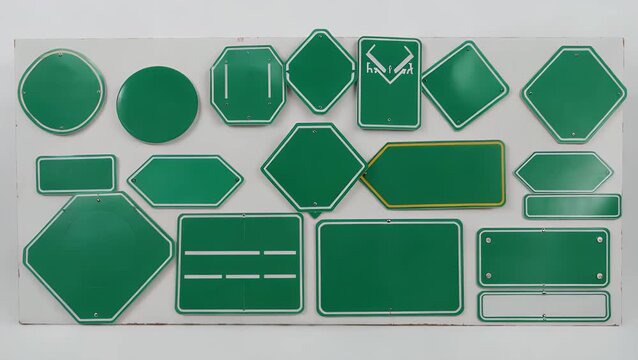 Assemblage of variously proportioned vacant verdant traffic direction panels on plain white setting