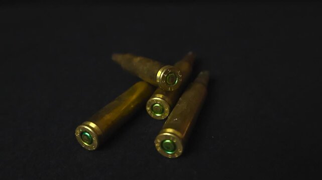 Close up view of bronze and golden colored blank cartridges or high caliber ammo ammunition bullets placed in front of a black studio background with shallow depth of field, Good studio lighting.