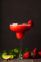 Strawberry margarita in cocktail glass on rustic table. Cocktails and beverages.
