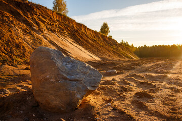 A large boulder lying at the bottom of a picturesque sand quarry
