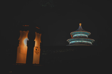 Night view of The Palace Museum in Beijing. Illuminated structures glow against a dark sky. A sense...