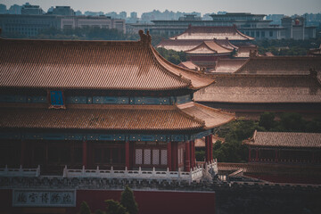 An aerial view reveals The Palace Museum in Beijing, showcasing its traditional architecture with curved, tiled roofs and historical building details. The buildings of the Palace Museum spread into th