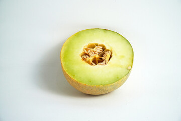 A fresh cantaloupe cut in half, revealing its juicy green flesh and seeds. The vibrant colors and simple composition on a white background make this photo perfect for themes of healthy eating, freshne