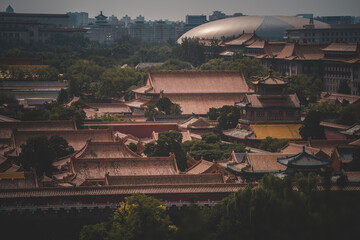 Aerial view of The Palace Museum in Beijing, capturing rooftops and surrounding greenery. A large...