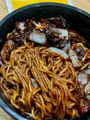 Classic jajangmyeon with thick noodles in a rich black bean sauce, garnished with sliced cucumber and sesame seeds. A beloved Korean-Chinese comfort dish, full of savory depth and flavor.