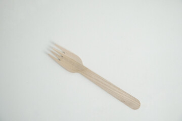 A single, eco-friendly wooden fork rests on a clean white background. This image is perfect for concepts of sustainability, zero-waste, and environmentally conscious dining.

