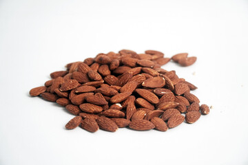 A pile of whole almonds rests on a clean white background. This image highlights the texture and richness of the nuts, perfect for themes of healthy eating, snacks, or food ingredients.

