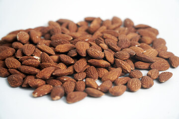 A pile of whole almonds rests on a clean white background. This image highlights the texture and richness of the nuts, perfect for themes of healthy eating, snacks, or food ingredients.

