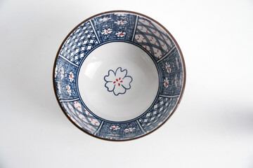 A beautiful Japanese-style ceramic bowl with a unique blue and white floral pattern and a ribbed exterior. Elegant themes of Asian cuisine, home decor, and authentic kitchenware.