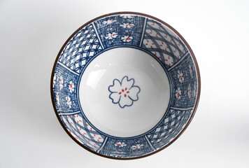 A beautiful Japanese-style ceramic bowl with a unique blue and white floral pattern and a ribbed exterior. Elegant themes of Asian cuisine, home decor, and authentic kitchenware.