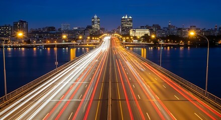 Fototapeta premium Cityscape at night with light trails on a bridge over water.