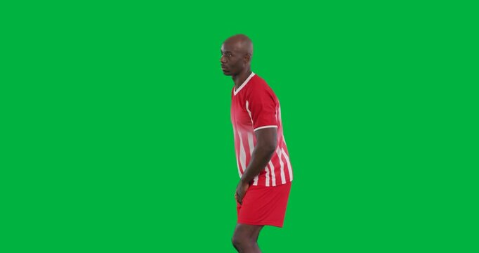 Video of african american male soccer player kicking ball isolated on transparent background