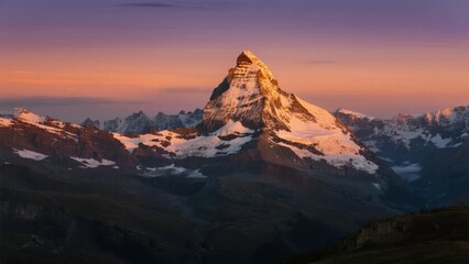 Naklejka premium Matterhorn mountain peak illuminated by sunrise with snow-covered slopes and alpine landscape