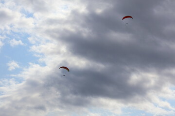 Close-up of two people paragliding in the sky, adventure sport, tandem flight, aerial recreation