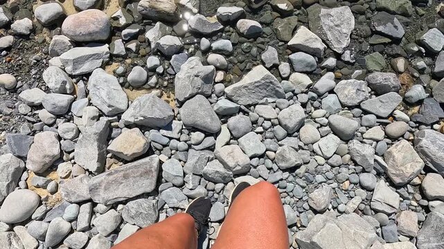 POV from a girl walking up and revealing Lake Tekapo in New Zealands south Island. You can see the rocks and stones initially and then it pans up to reveal the beautiful lake and mountains.