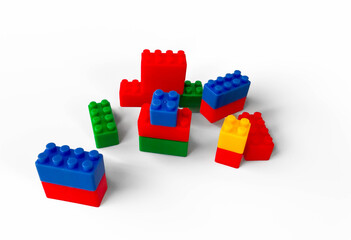 Fototapeta premium Colorful plastic toy building blocks arranged on a white background. 