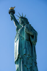 The iconic Statue of Liberty in New York City in front of a blue sky