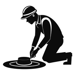 Construction worker kneeling inspecting manhole cover silhouette