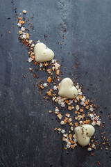 heart-shaped cookies and spices festive arrangement on a black slate background