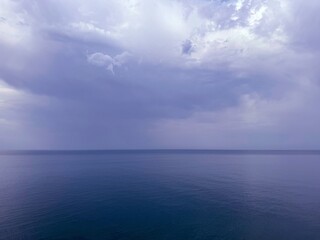 Overcast sky clouds over calm ocean.