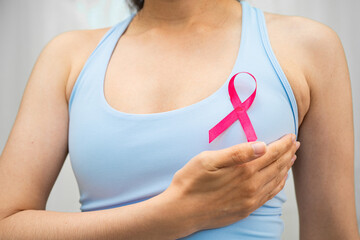 Breast cancer, pink ribbon at Asian senior lady for supporting awareness, symbol of World Breast Cancer Day.