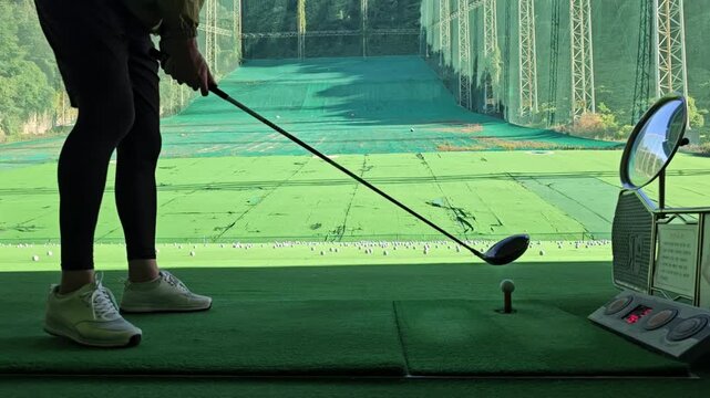 Video of golf swing at a golf practice range
