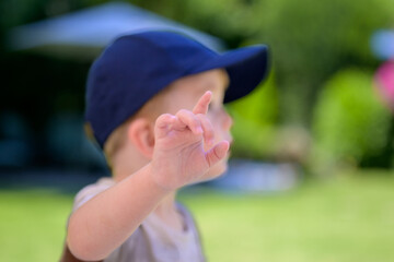 Child Pointing Wearing Blue Cap