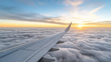 Obraz premium Aerial view of airplane wing above clouds during sunset, creating serene atmosphere