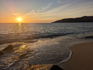 Beach with rocks and waves during sunset
