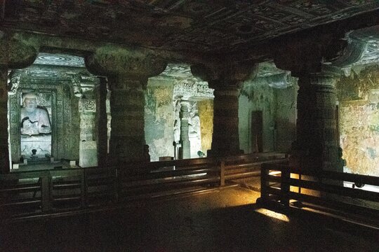 view of ajanta cave 1, showing it's finely carved stone pillars, detailed ancient artwork, and the central buddha shrine