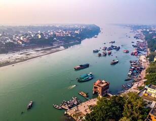 River cityscape boats ply a wide river in hazy golden light