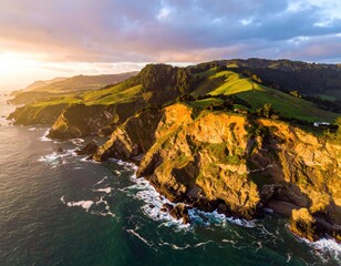 Coastal cliffs meet the ocean under a golden sunrise