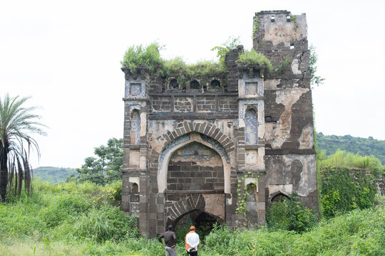 historic 'chini mahal' inside daulatabad fort, once a royal palace later used as a prison, now seen in partial ruins with persian style tiles and lush greenery around