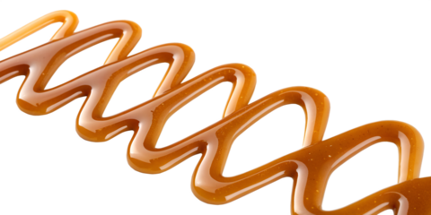 Close up of glossy caramel sauce drizzled in wavy lines on black swirl