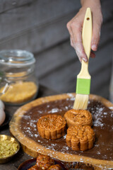 Brushing egg wash on traditional mooncake before baking