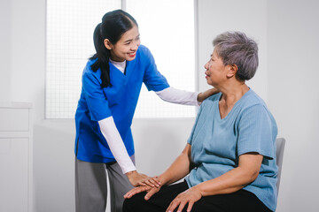 Obraz premium An Asian female nurse provides caring home care to an elderly woman, assisting with arm movement exercises, physical therapy,and rehabilitation to improve joint function, strength,overall well-being