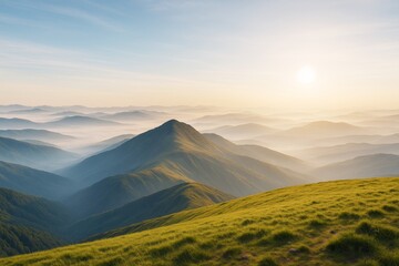 Fototapeta premium Peaceful sunrise over misty mountain landscape with green hills and layered ridges in soft morning light, scenic nature background.