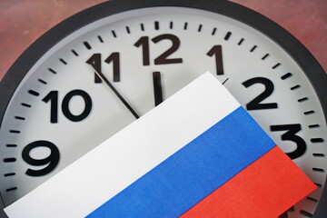 The Russian flag on the clock face on a paper background.