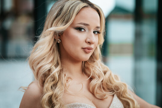 Beautiful close-up portrait of a caucasian woman with curly blonde hair and glamorous makeup