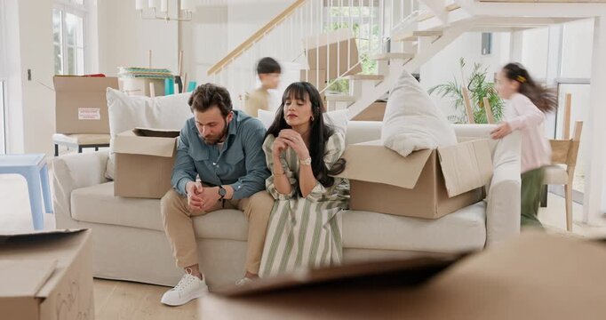 Children, running and family in house with boxes, frustrated and tired for moving. Hyper active, people and stress parents and renovations in home with playing, overwhelmed and headache for homeowner