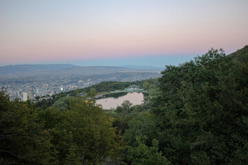 Mountain lake with a city view and sunset sky