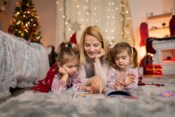 Mother reading a Christmas story to her daughters