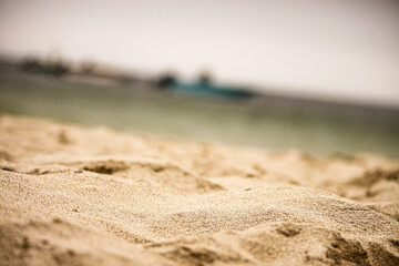 Close-up of sand texture with blurred sea background