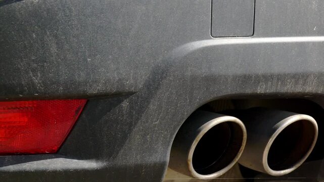 Close up or dirty rear bumper and exhaust with black trim
