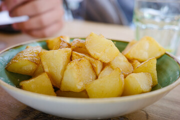 Golden fried potato cubes served in a ceramic bowl