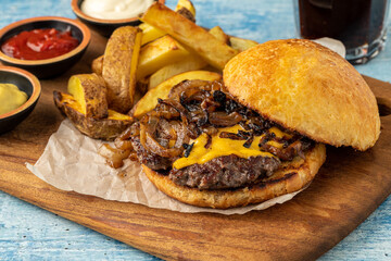 Smash burger with cheddar cheese and caramelized onions, served with fries