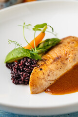 Grilled chicken fillet with black rice and vegetables in sauce