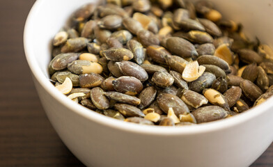 baked salted pumpkin seeds in a small white bowl