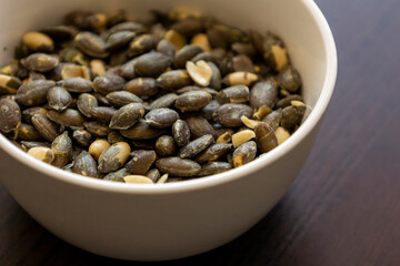 baked salted pumpkin seeds in a small white bowl