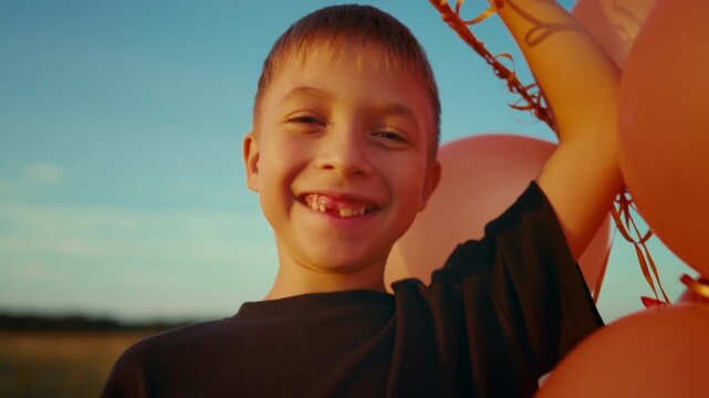 Celebrate summer holiday, 4th of July, portrait of happy boy with balloons. Carefree little child smiling to camera, funny smile without one tooth, stay positive and be yourself, happy childhood